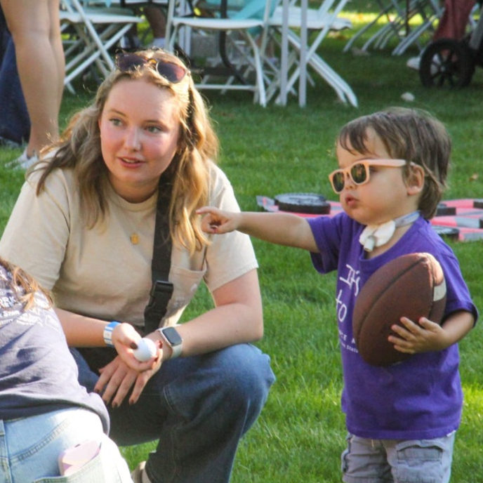 families committee member talking to a miracle kid holding a football