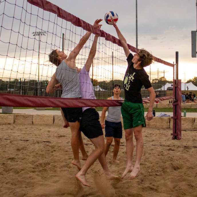 Students playing sand volleyball