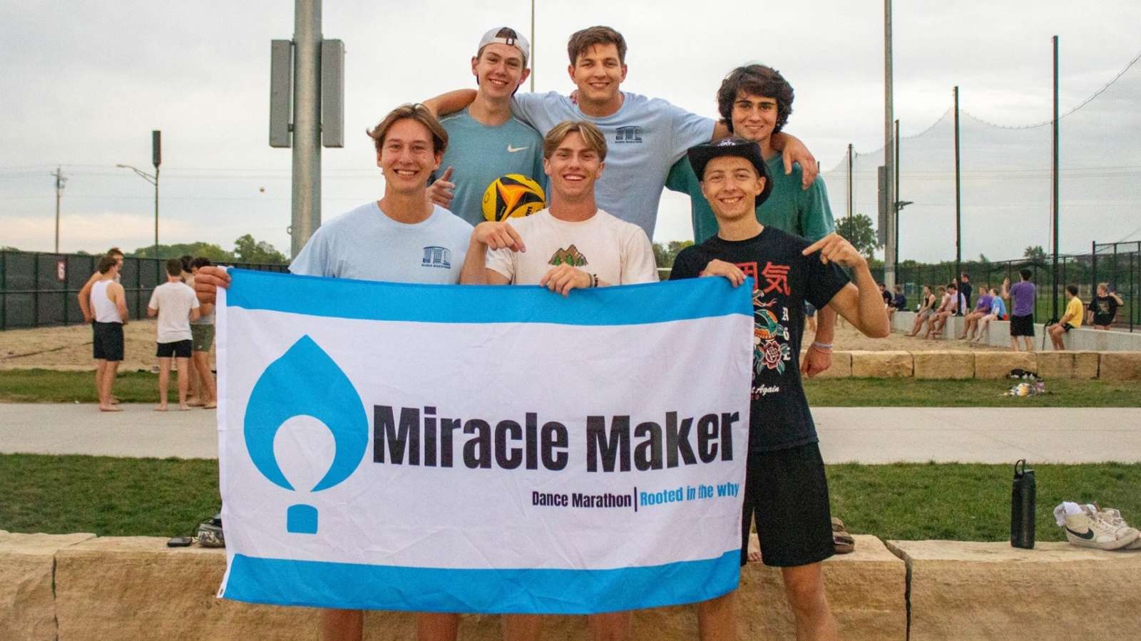 Team of 6 people holding Miracle Maker flag at Digs for DM 2023