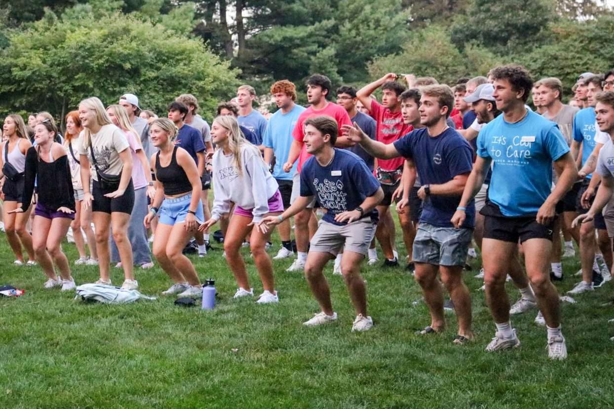 group of students standing outside moving around