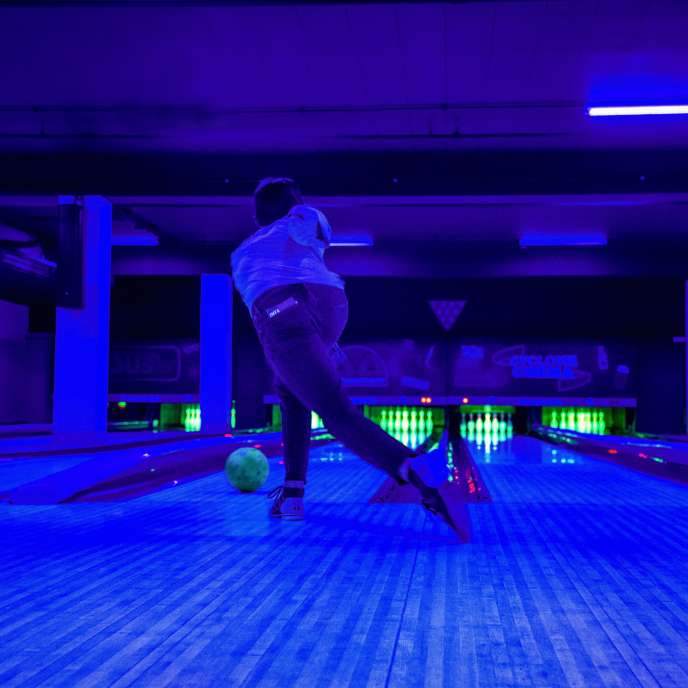 person bowling in blacklight